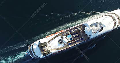 Aerial view of luxury medium cruise ship sailing from port on sunrise