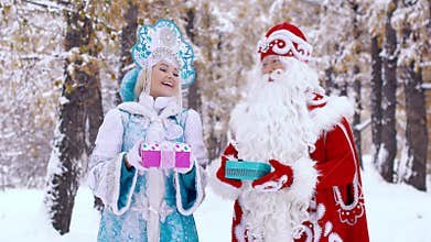 Portrait of man and woman dressed in New Year costumes holding gifts in hands
