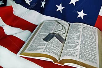 military dog tags on Bible with flag