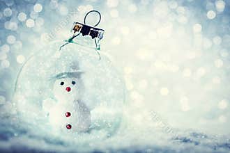 Christmas glass ball with snowman inside. Snow and glitter