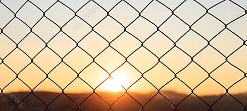 Wire mesh fence on a sunset background