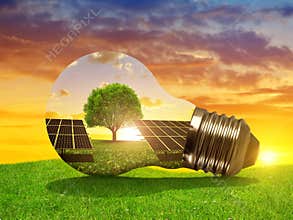 Solar energy panels in light bulb at sunset.