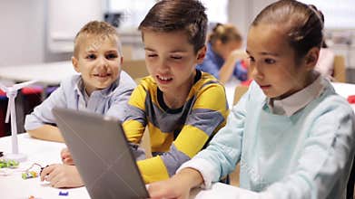 Kids with tablet pc programming at robotics school