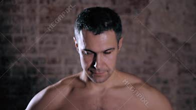 Handsome mature male model standing topless close up portrait on brick background, serious man