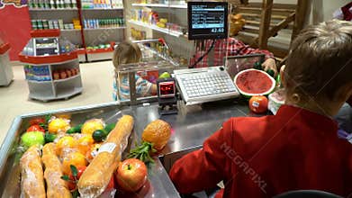 Boy cashier worker recording cost of items on cash register.