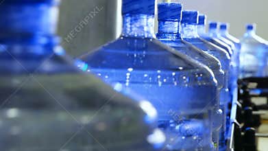 Big pure water bottles moving on the conveyor belt