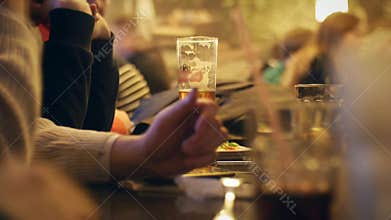 People sit in the evening in the pub and drinking beer.