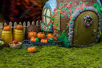 Fairy house in the forest with berries and pumpkins