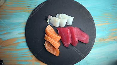 Hand putting sashimi on a slate plate