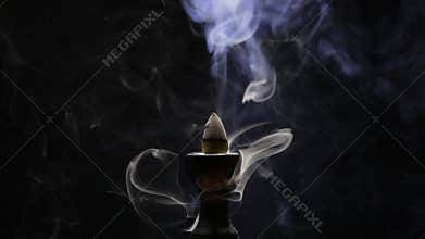 Aromatic cone smoldering in a ceramic stand