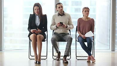 Three people waiting for job interview