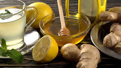 Ginger tea with lemon, mint and honey on wooden background.