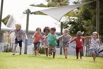Children At Montessori School Having Fun Outdoors During Break