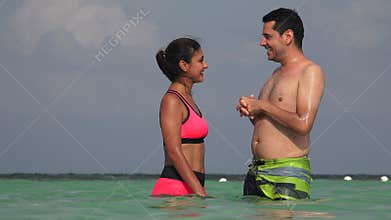 People Having Fun Swimming In Ocean On Vacation