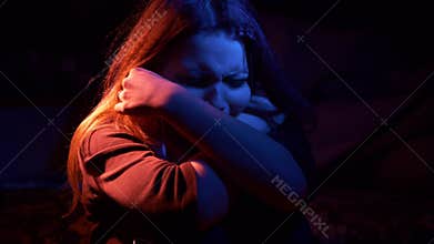 Unhappy sad teenage girl at night. Highly expressive.