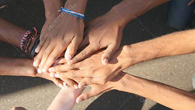 Arm of all races and colors stacked together one by one in unity and teamwork and then raised. Many multiracial hands