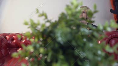 Beautiful blond girl in black dress and black pantyhose talking on the phone on the speakerphone.