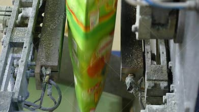 Packaging machine at workshop of food factory Process of packaging candy in foil package Factory worker Automated