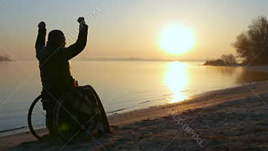 Sunset hands up on wheel chair, lonely disabled on wheelchair, male