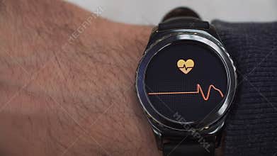 Smartwatch showing the heart rate to the user. The watch is on his right hand