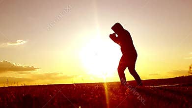 Silhouette of man exercising thai boxing. Silhouette of martial arts man training boxing on the beach over beautiful sunset backgr