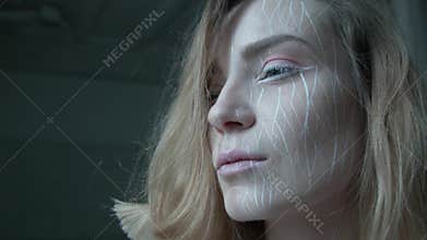A blonde with artistic make-up raises her head and looks boldly forward. A young woman is full of determination in her