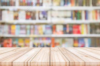 Empty wooden table top with Blur bookshelves in bookstore background.