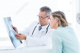 Doctor having conversation with his patient and holding xray
