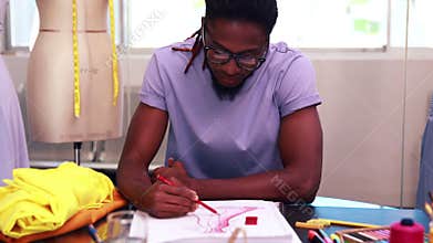 Focused fashion student drawing a dress