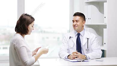Smiling doctor and young woman meeting at hospital