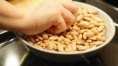 Hand taking Almond seed from bowl