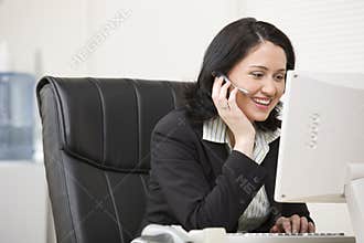 Woman in headset working at computer