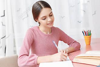 Teenage girl writing in her exercise book