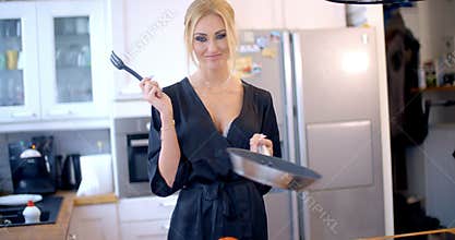 Cute blond woman cooking in the kitchen