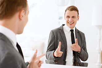 Man looking in mirror and pointing on himself