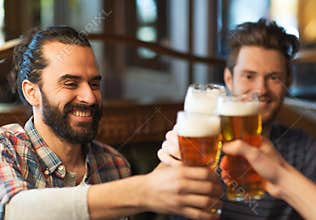 Happy male friends drinking beer at bar or pub