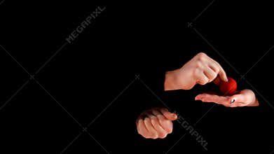 Magician trick with red balls on black background