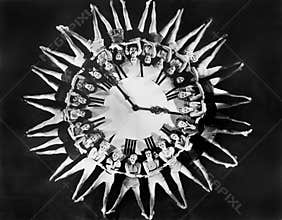 Female dancers circling huge clock