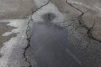 Puddle on asphalt alike a human figure with halo.