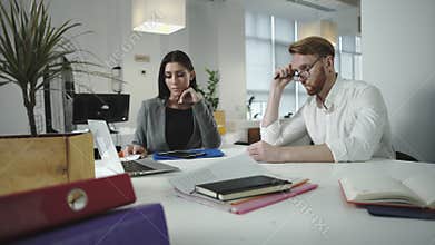 Employees discussing work in the office. looking on laptop together