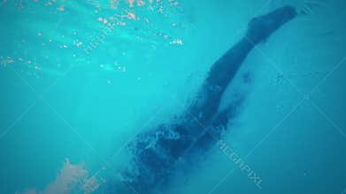 Underwater view of athletic man diving in the swimming pool