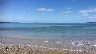 Young man surfing on paddle boarding