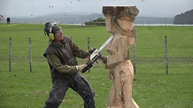 Wood sculpture sculpting a statue with a chainsaw.