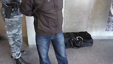 Armed policeman arresting man