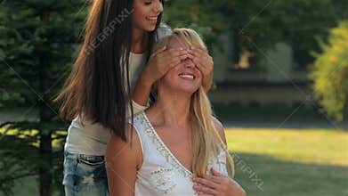Daughter cover mother's eyes