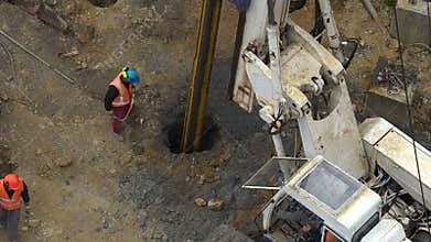 Unrecognizable workers with hydraulic hammer drilling machine at