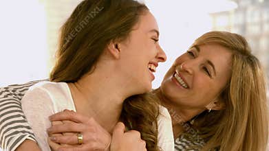 Mother and daughter hugging on the sofa