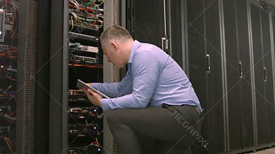 Technician using tablet pc while analysing server