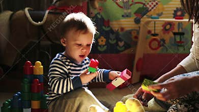 Mother playing with her baby boy with toys