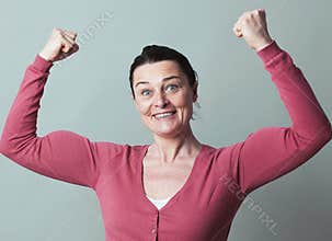 Joyous beautiful 40s woman flexing her muscles up